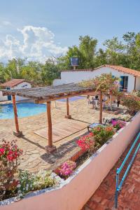 una terraza de madera con flores y una piscina en Hotel Y Spa Santos De Piedra, en Barichara