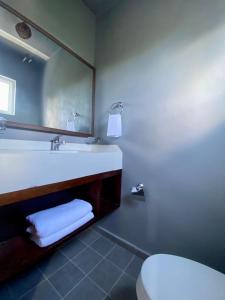 a bathroom with a sink and a toilet and a mirror at Casa Cielito Lindo Cozumel in Cozumel