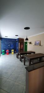 a room with wooden tables and a blue wall at Joshua Tree Hostel - Curitiba in Curitiba
