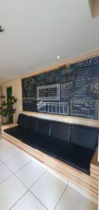 a bench in a restaurant with a chalkboard wall at Joshua Tree Hostel - Curitiba in Curitiba