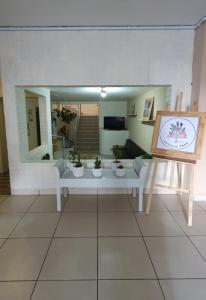 Joshua Tree Hostel - Curitiba في كوريتيبا: غرفة معيشة مع أريكة بيضاء ومرآة
