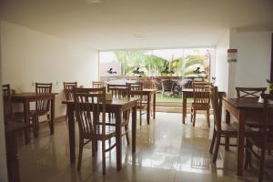 a dining room with wooden tables and chairs at Pousada Xerxes in Arraial do Cabo
