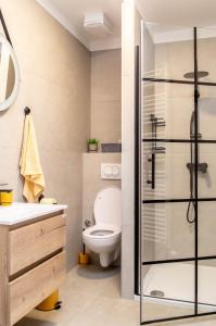 um banheiro com vaso sanitário e box de vidro em Kirabela Apartment em Zagreb