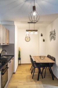 cocina y comedor con mesa de madera y sillas en Kirabela Apartment en Zagreb