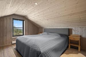 a bedroom with a bed and a window at Ny og moderne feriehytte in Drangedal