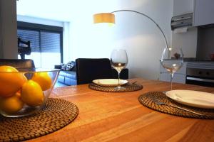 - une table avec deux verres de vin et un bol de fruits dans l'établissement Moderno apartamento en el Campello by beBalmy, à El Campello