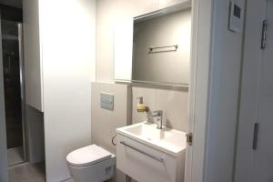 La salle de bains est pourvue d'un lavabo, de toilettes et d'un miroir. dans l'établissement Moderno apartamento en el Campello by beBalmy, à El Campello