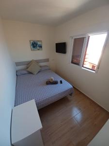 Dormitorio pequeño con cama y TV en Apartamento jardin del mar 7.5, en La Manga del Mar Menor