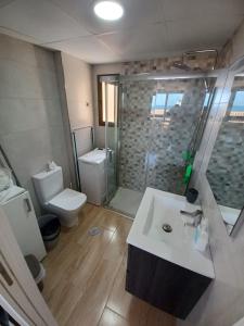 uma casa de banho com um lavatório, um chuveiro e um WC. em Apartamento jardin del mar 7.5 em La Manga del Mar Menor