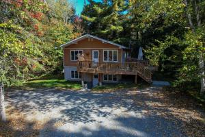 a house with a large deck in the woods at COZY CHALET WELL LOCATED in Saint-Faustin