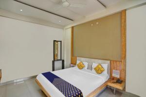 1 dormitorio con 1 cama grande con almohadas amarillas y azules en SPOT ON Hotel Harmony en Muthiganj