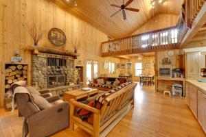 a living room with a stone fireplace in a log house at Pet-Friendly House with Deck Near Crater Lake! in Fort Klamath
