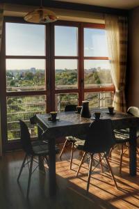 a table and chairs in a room with a large window at GreenView Apartment in Rzeszów