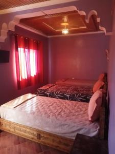 阿加迪爾的住宿－gite rurale Sousse paradis Vallée，一间设有两张床的卧室,位于带红色窗帘的房间