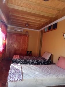 阿加迪爾的住宿－gite rurale Sousse paradis Vallée，一间卧室设有两张床和木制天花板