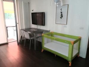 a living room with a table and a green bench at Locazione Turistica La Rosa - Navigatori in Verona