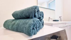 a pile of towels sitting on top of a bathroom counter at Chez JM - Calme - Chic - Fibre - Relax BNB in Mulhouse +32 photos