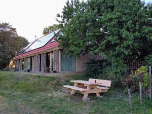a picnic table in front of a building with a tree at De Kinkhoorn in Ezinge