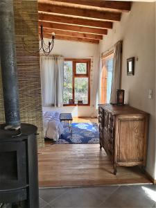 sala de estar con cama y estufa de leña en Casa luminosa y confortable rodeada de naturaleza en San Carlos de Bariloche