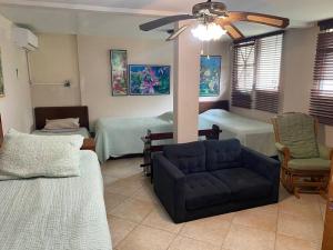 uma sala de estar com duas camas e um sofá em Coronado Beachfront tropical home! em Playa Coronado