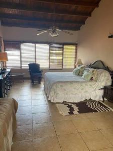 a bedroom with a bed and a couch and windows at Coronado Beachfront tropical home! in Playa Coronado
