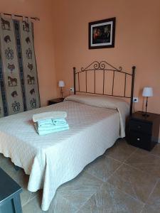 - une chambre avec un lit et 2 serviettes dans l'établissement Casa Rural Patio Rociero, à El Rocío