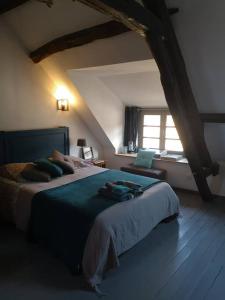 ein Schlafzimmer mit einem großen Bett und einem Fenster in der Unterkunft Au cœur de Mortagne, un balcon sur le Perche in Mortagne-au-Perche