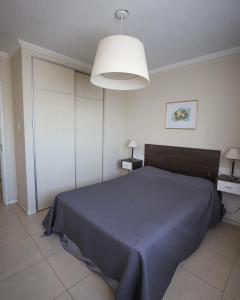 1 dormitorio con 1 cama con manta azul en Departamento de un dormitorio - CRESPO en Santa Fe