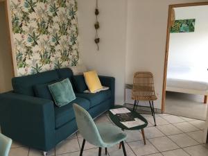 a living room with a blue couch and a table at La marine D'opale in Ambleteuse