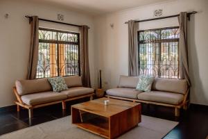 a living room with two couches and a coffee table at Tropicana House in Arusha