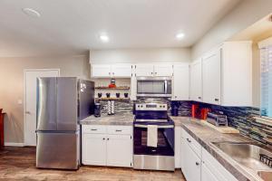 een keuken met witte kasten en een roestvrijstalen koelkast bij Jordan Oak in Groveland