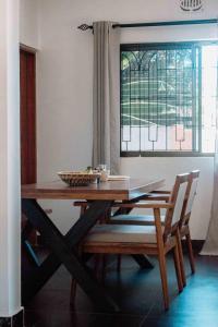 a wooden table with two chairs and a window at Tropicana House in Arusha