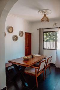 - une salle à manger avec une table et des chaises en bois dans l'établissement Tropicana House, à Arusha