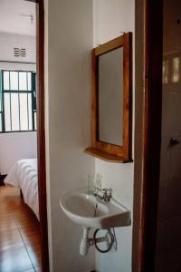 La salle de bains est pourvue d'un lavabo et d'un miroir mural. dans l'établissement Tropicana House, à Arusha