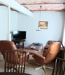 - un salon avec deux chaises, une table et une télévision dans l'établissement Bøelgaarden, à Gørding
