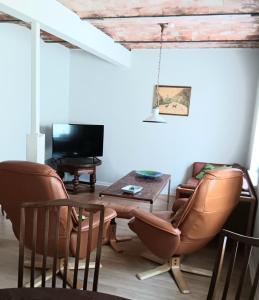 a living room with two chairs and a table and a television at Bøelgaarden in Gørding