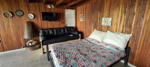 a bedroom with a bed and a couch and a television at Monoambiente Cañuelas Centro calle Principal hasta 4 personas in Cañuelas +13 photos