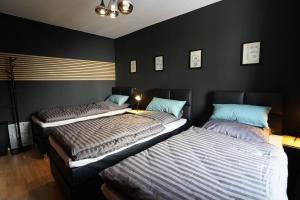 two beds in a room with black walls at Downtown/Balcony/Coffee Bar/TV-Streaming/top WLAN in Bielefeld +26 photos