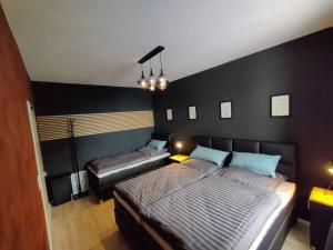 2 Betten in einem Schlafzimmer mit schwarzen Wänden in der Unterkunft Downtown/Balcony/Coffee Bar/TV-Streaming/top WLAN in Bielefeld