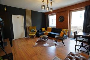 ein Wohnzimmer mit einem schwarzen Sofa und Stühlen in der Unterkunft Downtown/Balcony/Coffee Bar/TV-Streaming/top WLAN in Bielefeld