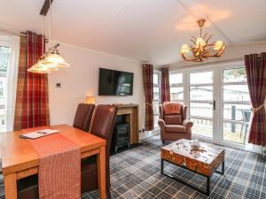 a living room with a table and a dining room at Loch Lomond Holiday Home in Arrochar