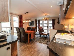 a kitchen and living room with a table and a dining room at Loch Lomond Holiday Home in Arrochar