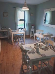 jadalnia ze stołami i krzesłami oraz oknem w obiekcie Loughcrew View Bed and Breakfast w mieście Kells