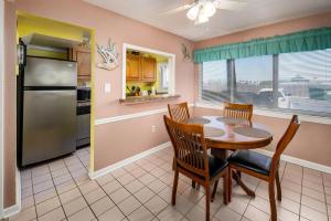 uma cozinha com uma mesa e cadeiras e um frigorífico em Seaspray Condos 115B em Fort Walton Beach