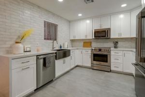 a kitchen with white cabinets and stainless steel appliances at Fully Renovated Phoenix Condo with Pool-View Balcony in Phoenix