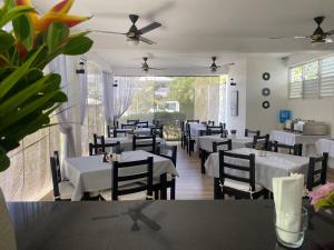 Diamond Hotel Cabarete في كاباريتي: غرفة طعام مع طاولات وكراسي بيضاء