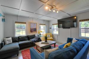 a living room with blue couches and a tv at Spacious Winder Getaway with Hot Tub and Game Room! in Winder