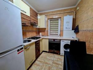 a kitchen with a white refrigerator and a dishwasher at Urban Nest Barlad in Bîrlad