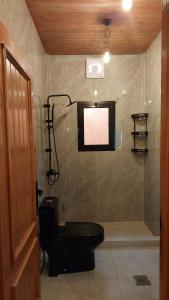a bathroom with a toilet and a shower in a room at شاليهات اكواخ الروز in Khalij Salman