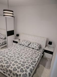 1 dormitorio con 1 cama y 2 mesitas de noche en Bella apartman en Mladenovac